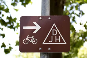Nowoczesny ciągnik rolniczy z kabiną ochronną zaparkowany na wiejskiej drodze w świetle zachodzącego słońca.