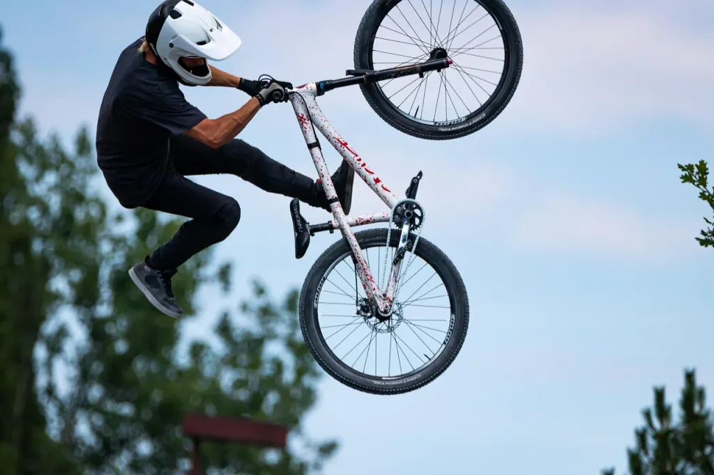 Rowerzysta górski pokonujący wymagający teren podczas wystawy sprzętu sportowego.