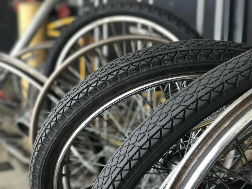 Serwisant wymienia oponę w kole rowerowym, dbając o sprawność techniczną jednośladu.